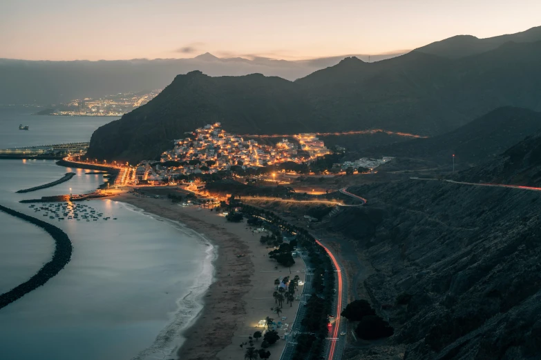 an aerial s of a beach in front of some mountains