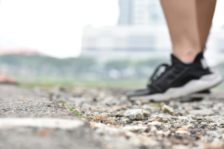 a person's legs, walking on gravel with grass