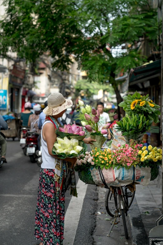 a woman standing in the street with many flowers