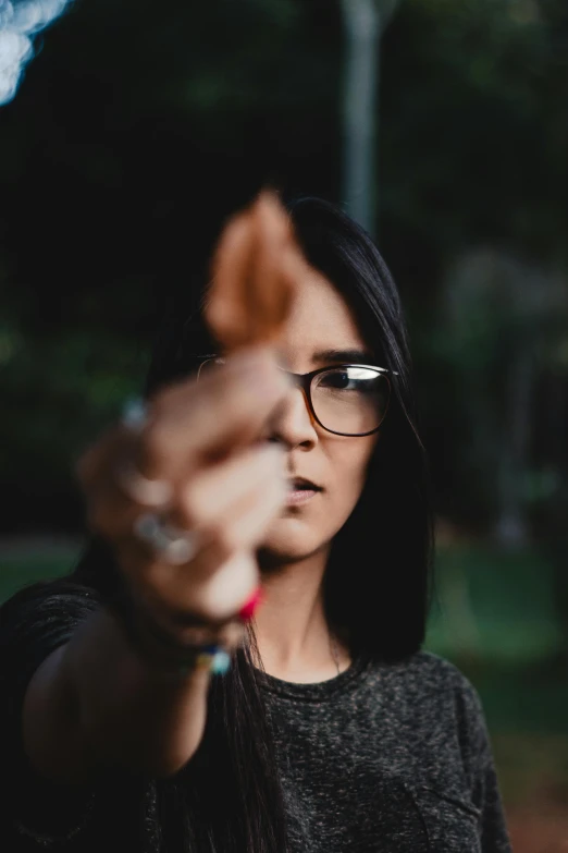 a woman wearing glasses holding out a glass