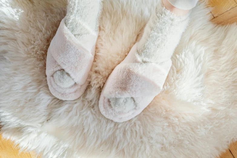 the baby shoes are laying on a white fluffy mat