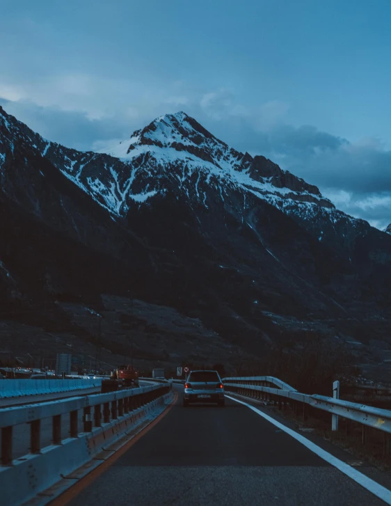 a view of a highway at night with mountains in the distance