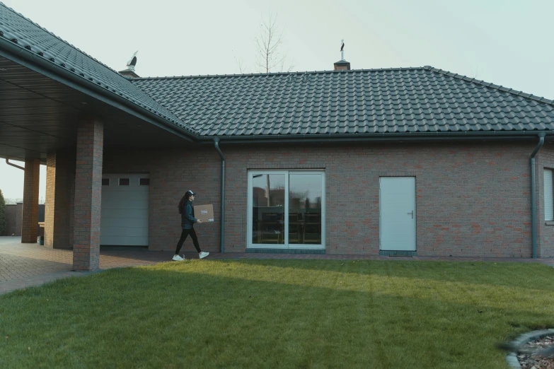 a man walking towards a large brick house