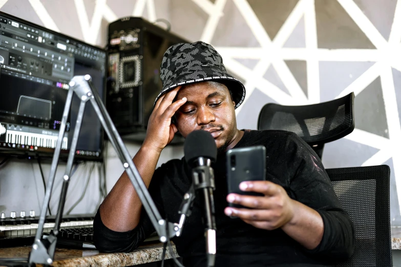 a young man sitting at a table using his cell phone