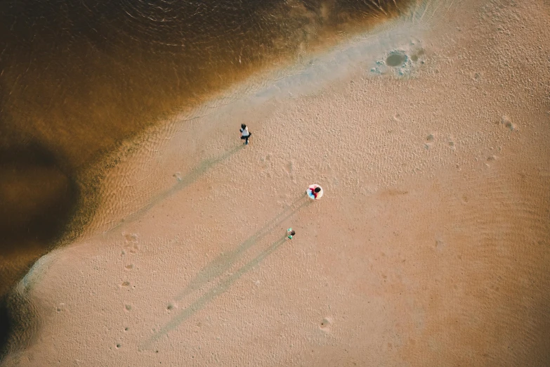 an overhead view of three people on a beach