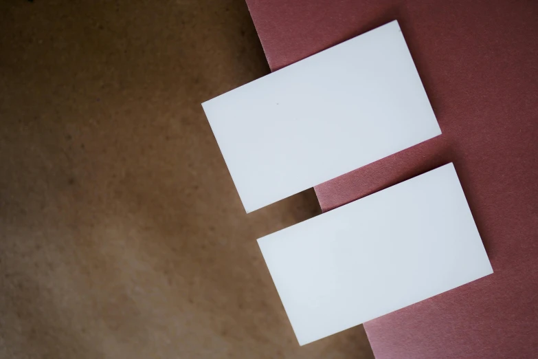 two white tags on a pink piece of paper