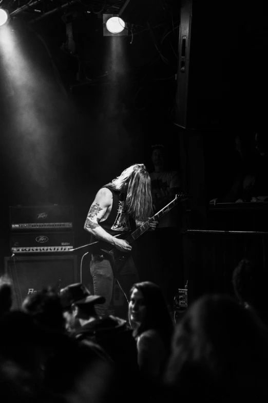 black and white pograph of a male performing on stage with audience