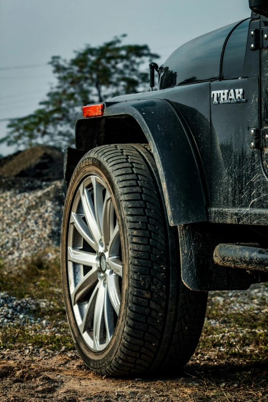 a black truck parked in the dirt near the ocean