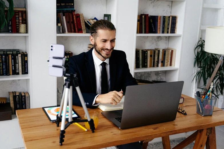 a man that is sitting in front of a laptop