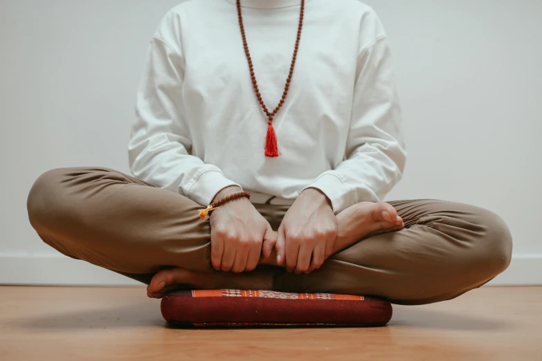 a man is sitting on the ground in meditation position