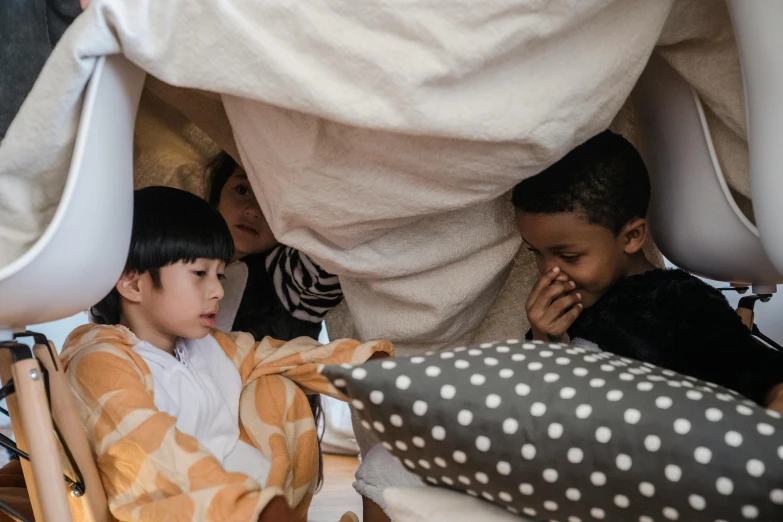 a group of young people sitting around a giant bed