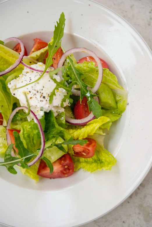 a bowl of salad with some sort of dressing on top of it