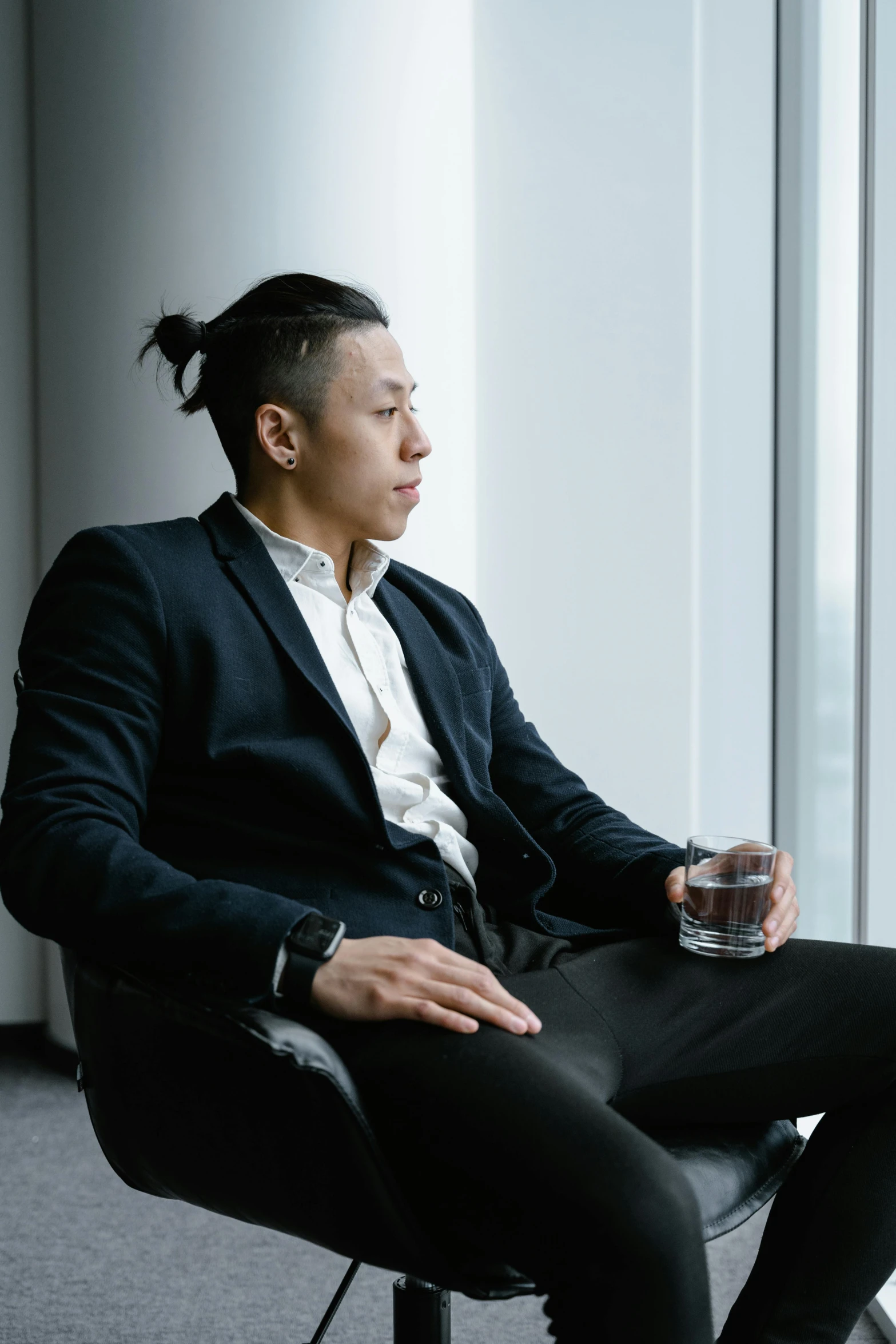 a person sitting in a chair with a glass in front of them