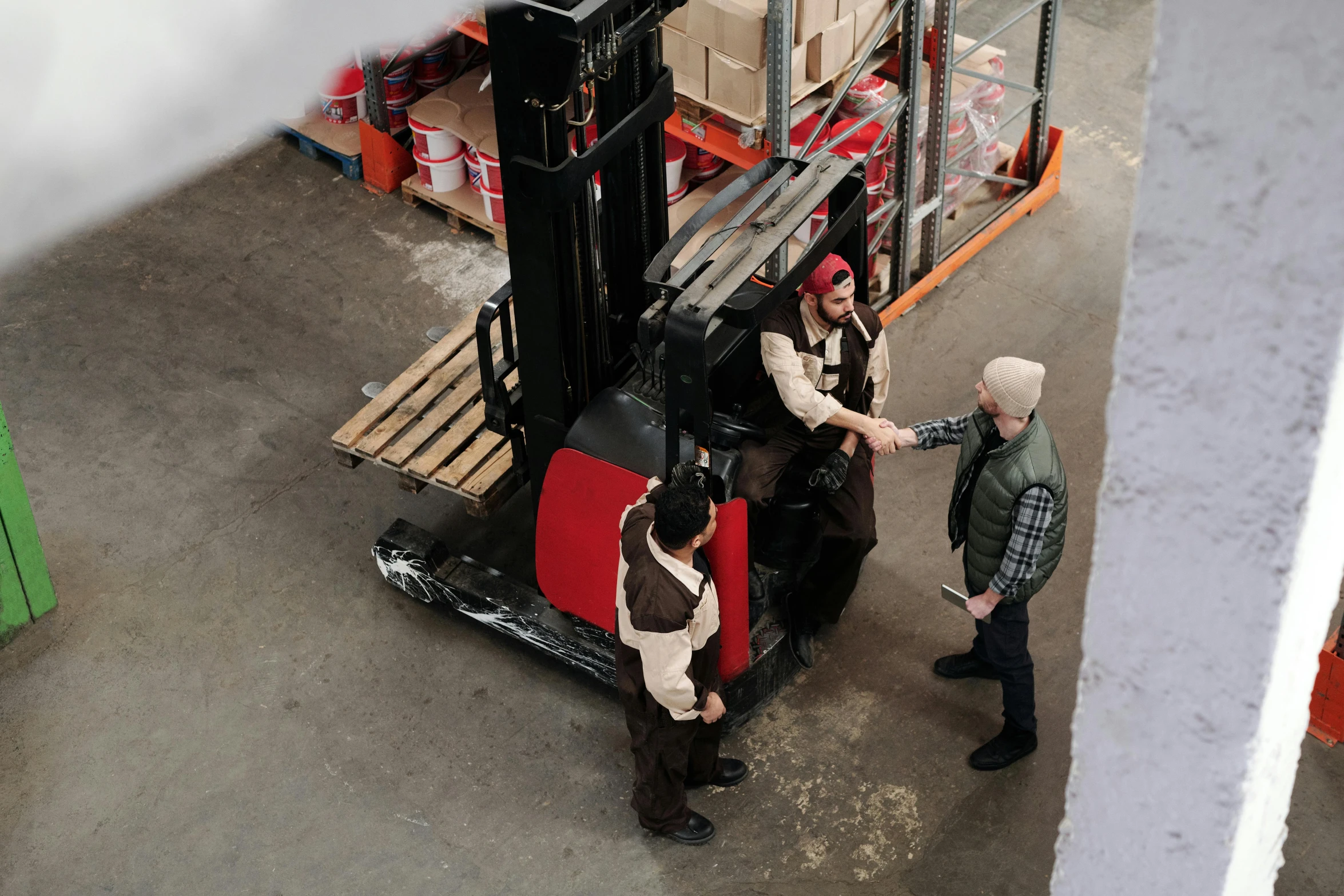 men in overalls are moving boxes on a forklift