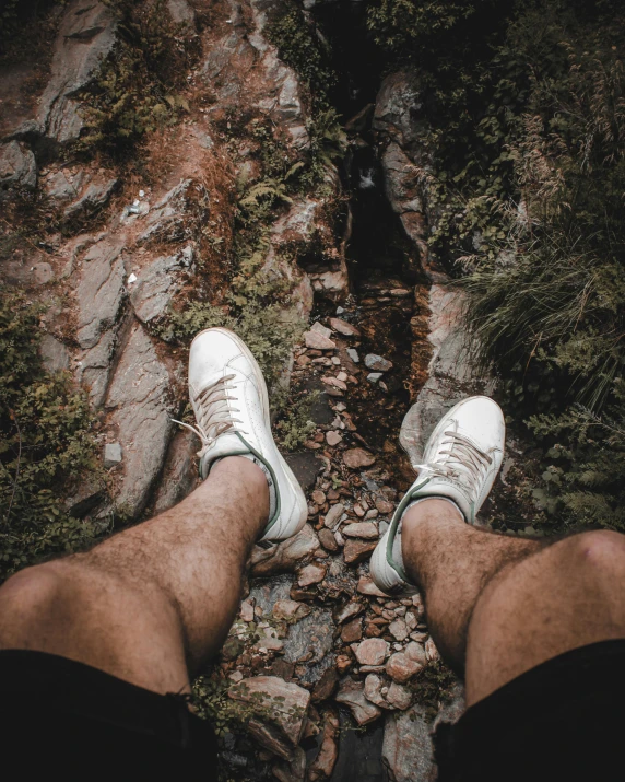 someone is standing on some rocks and there are many trees