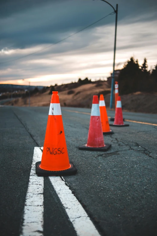 a row of cones sitting on the side of a road