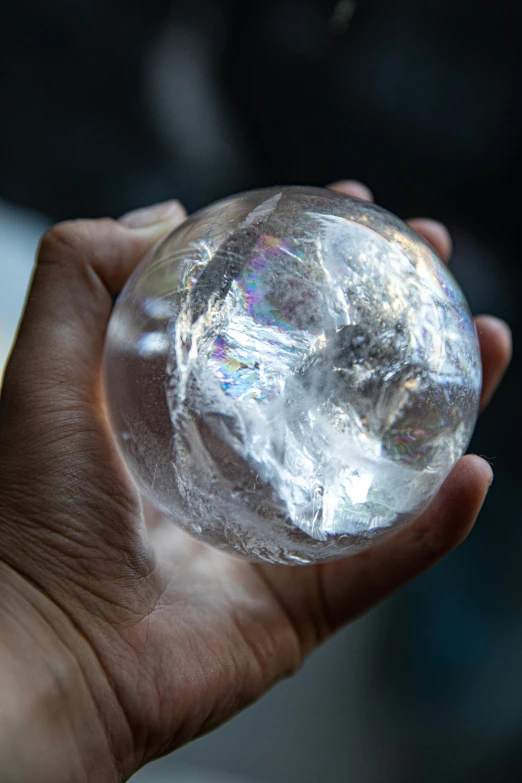 a close up of a person holding a crystal ball