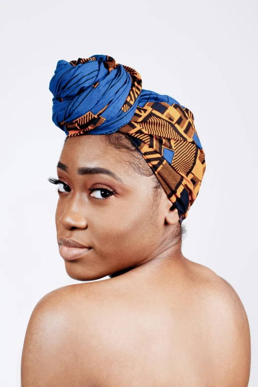 a beautiful young woman wearing a patterned blue head covering