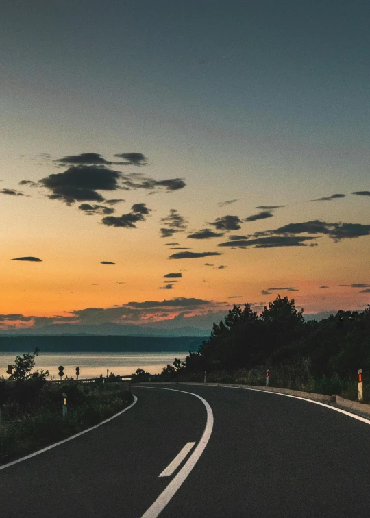 a car on a road with a sunset view