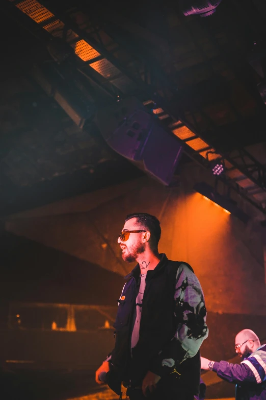 two people, one holding the other up, are standing together in front of lights