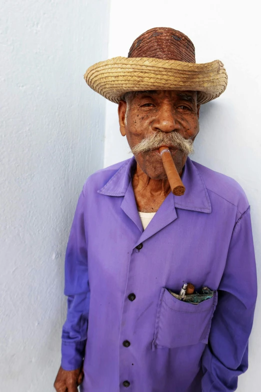 a man in purple shirt smoking a cigar