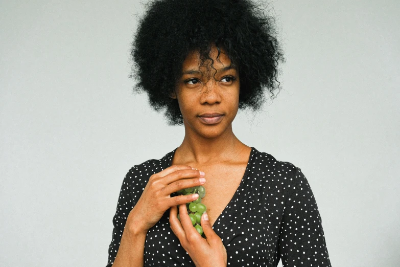 a woman holding up a piece of broccoli