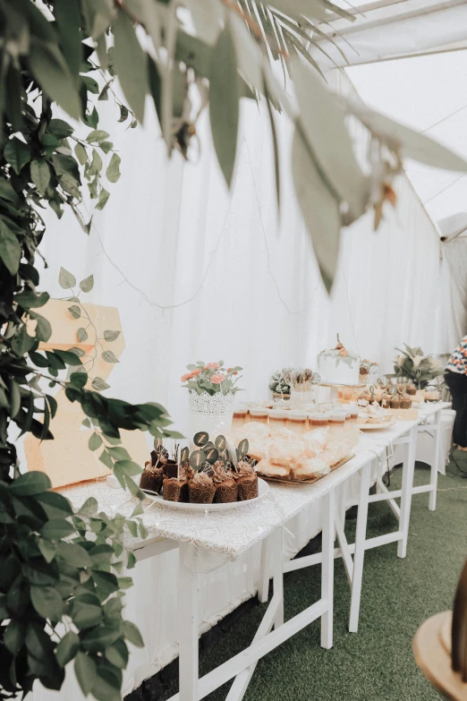 a banquet table has a cake, cupcakes and desserts