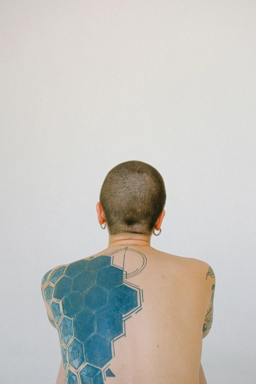 an image of a woman looking back with geometrical tattoo on her back