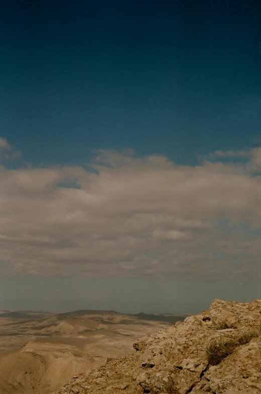 some people sitting on a hill with a blue sky in the background