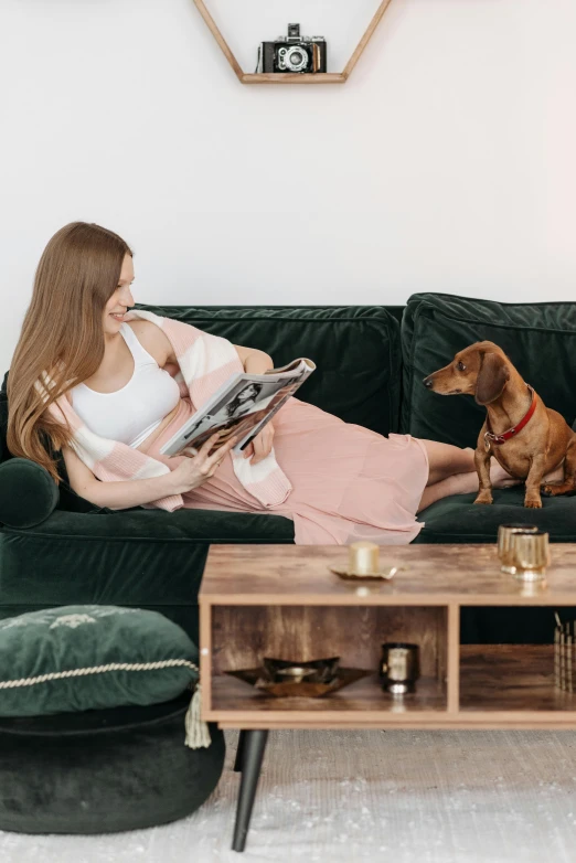 a woman reads a magazine while sitting on a couch