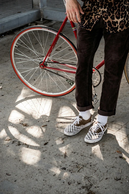 a man is standing next to his bicycle in front of his house