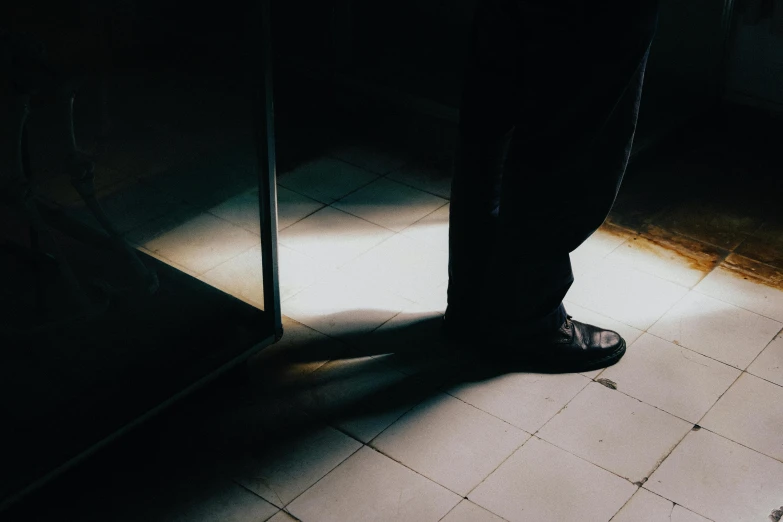 a person standing near a door, casting a shadow