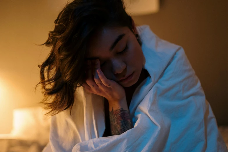 a woman covers her face with a white towel