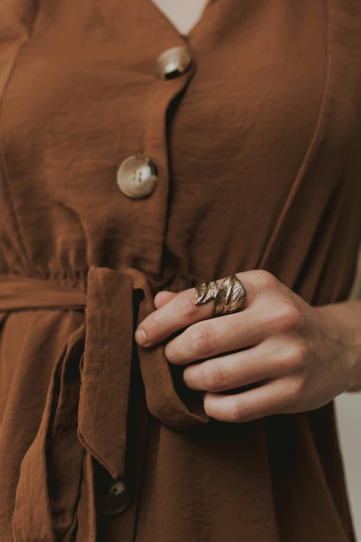 a womens hands with a ring and some gold metal