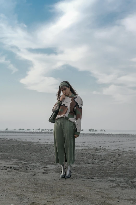 woman holding baby on the beach in front of the sky