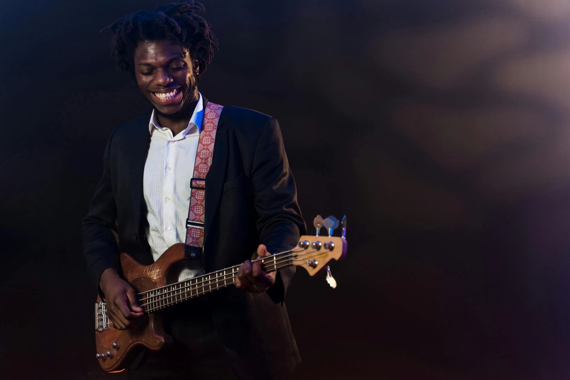 a man is holding a guitar and smiling