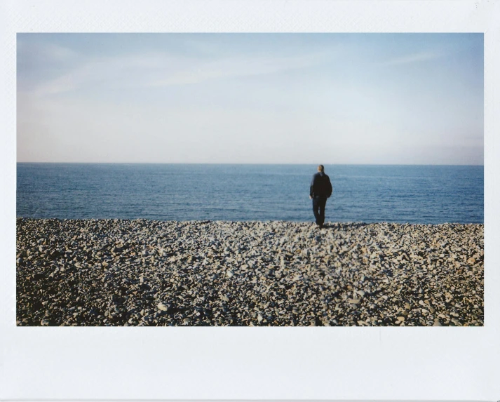 a man is walking on the beach as seen from a distance