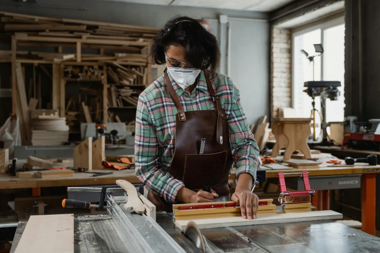 woman using a machine to make woodwork work