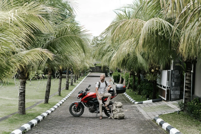 a man with a motorcycle sitting in the middle of a street