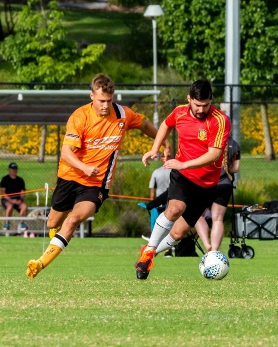 two men are running towards a soccer ball