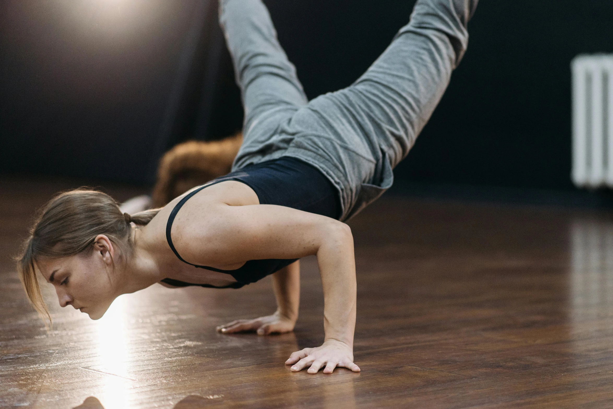 a woman in black top doing a downward pose