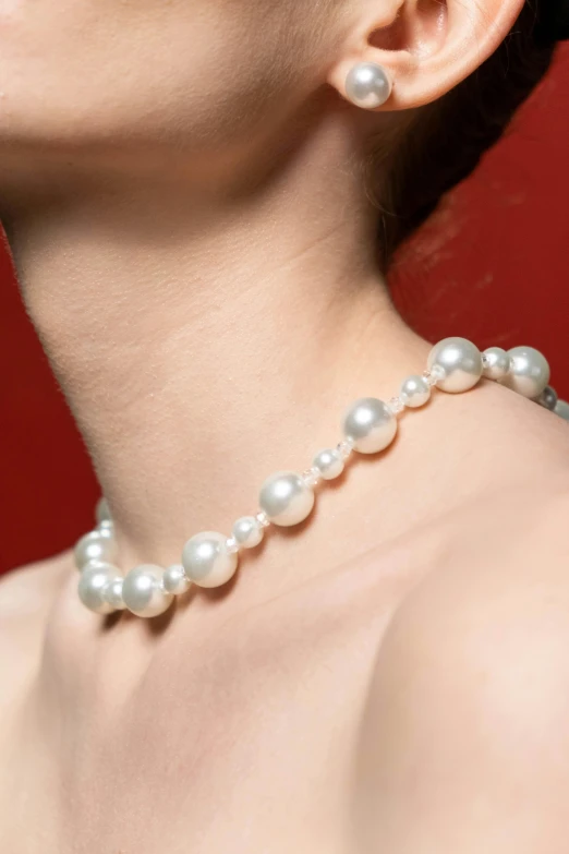 a woman wearing pearls and a necklace