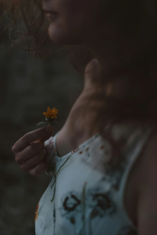 a woman holding a sunflower in her hands