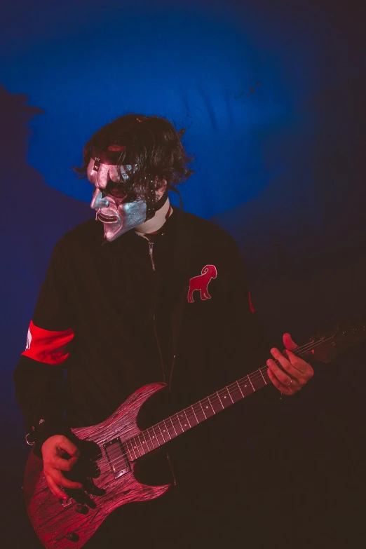 a man with face makeup and holding a guitar