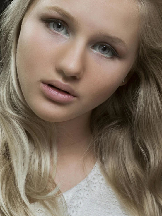 a girl in white shirt with her hair blowing out