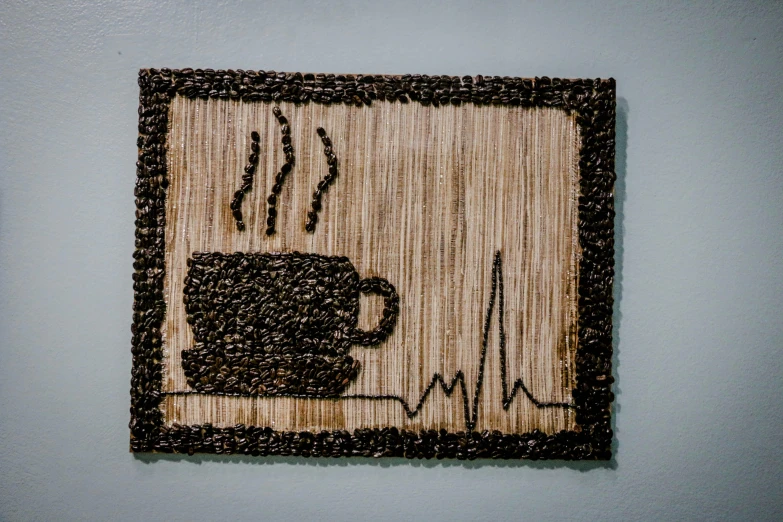 a black and brown wall hanging with a cup of coffee