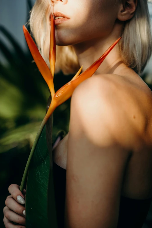 a beautiful blond woman posing with some flowers