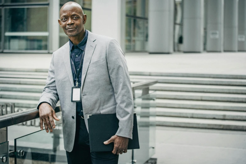 a man wearing a suit and shirt in front of a building