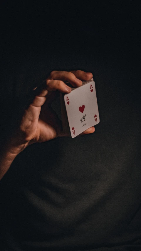 person holding up playing cards in their hands