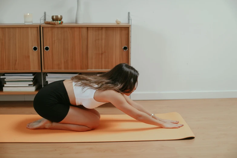 a beautiful woman is sitting on the floor doing exercises